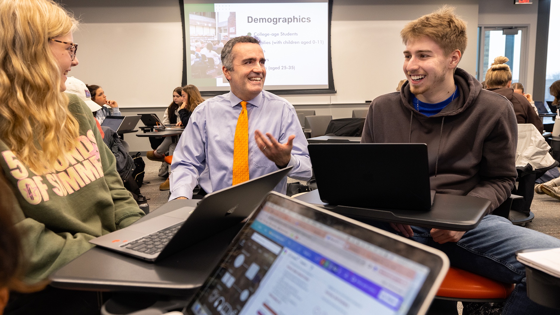 A BGSU associate professor speaking to two students in his class.