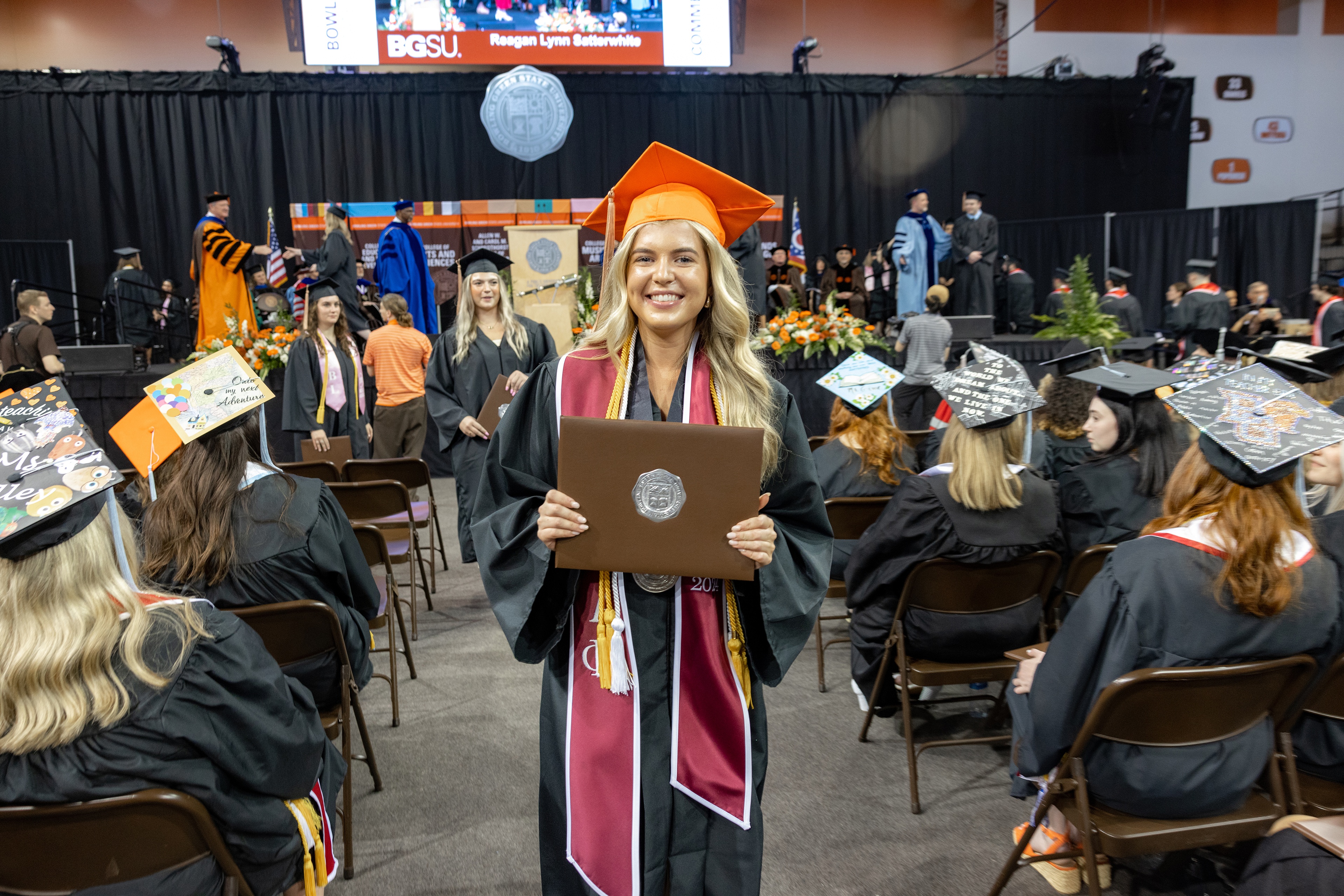 Female graduate holds her diploma cover