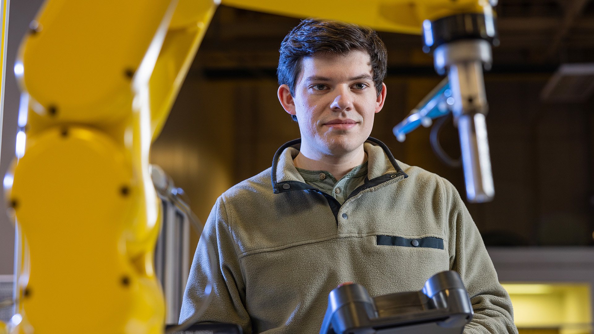 A person looks at an industrial robot.