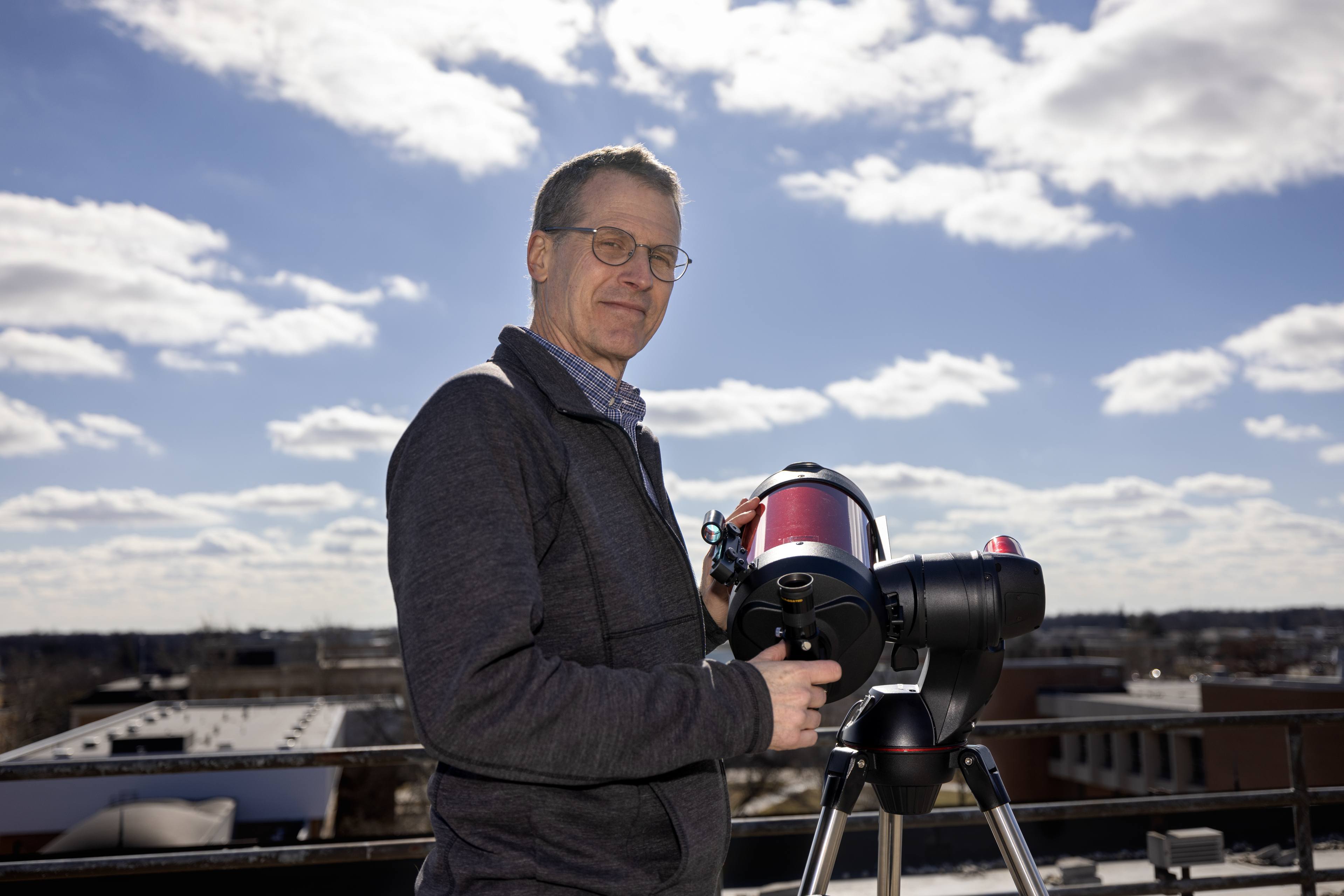 Dr. Andrew Layden stands in front of a telescope overlooking Bowling Green. 