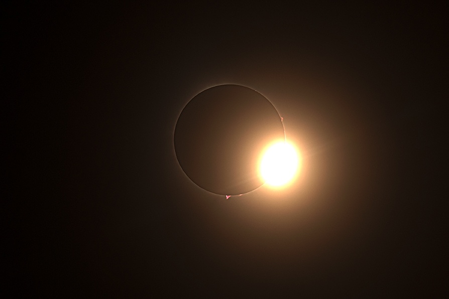 Solar eclipse photo shows the diamond ring effect where a bit of sun appears with the ring of corona attached 