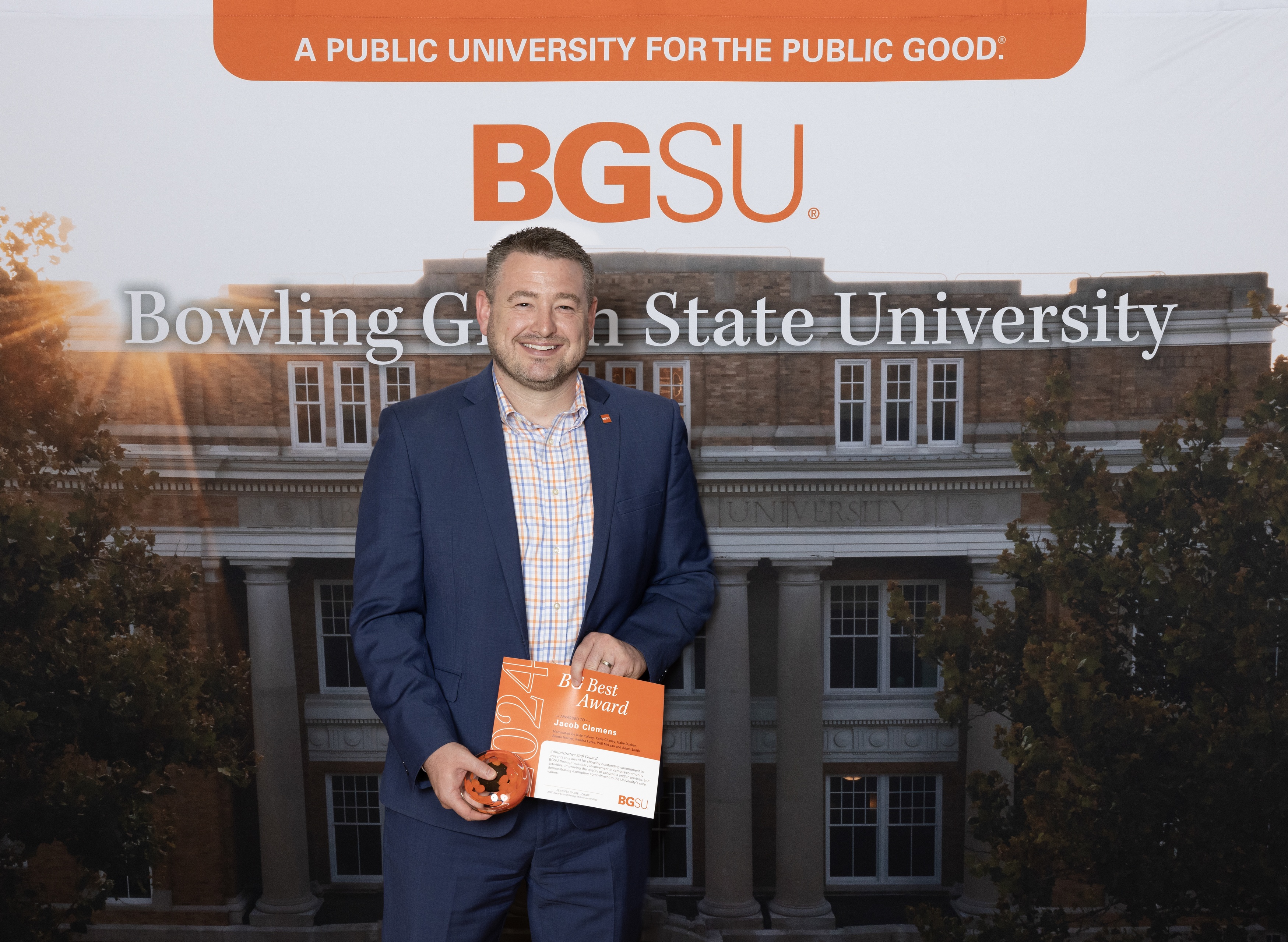 A man holds an award certificate 