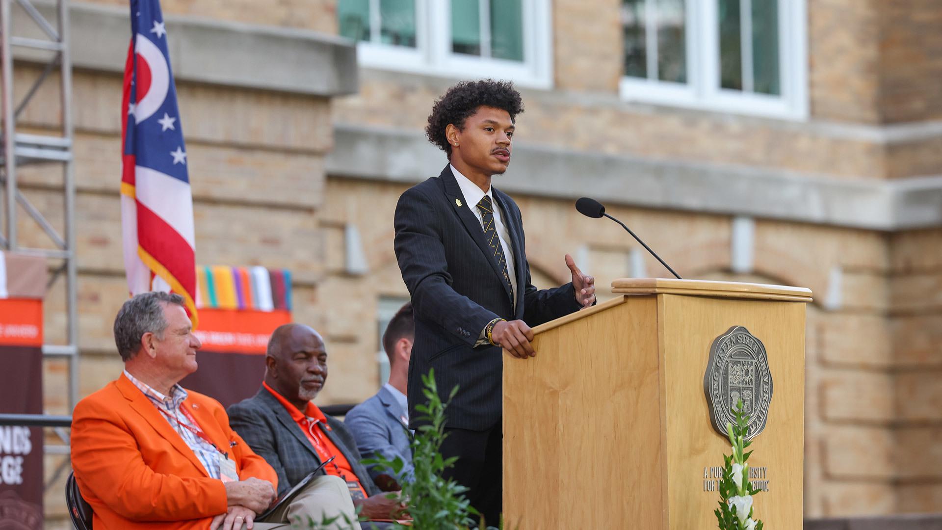 A male student stands at a podium.