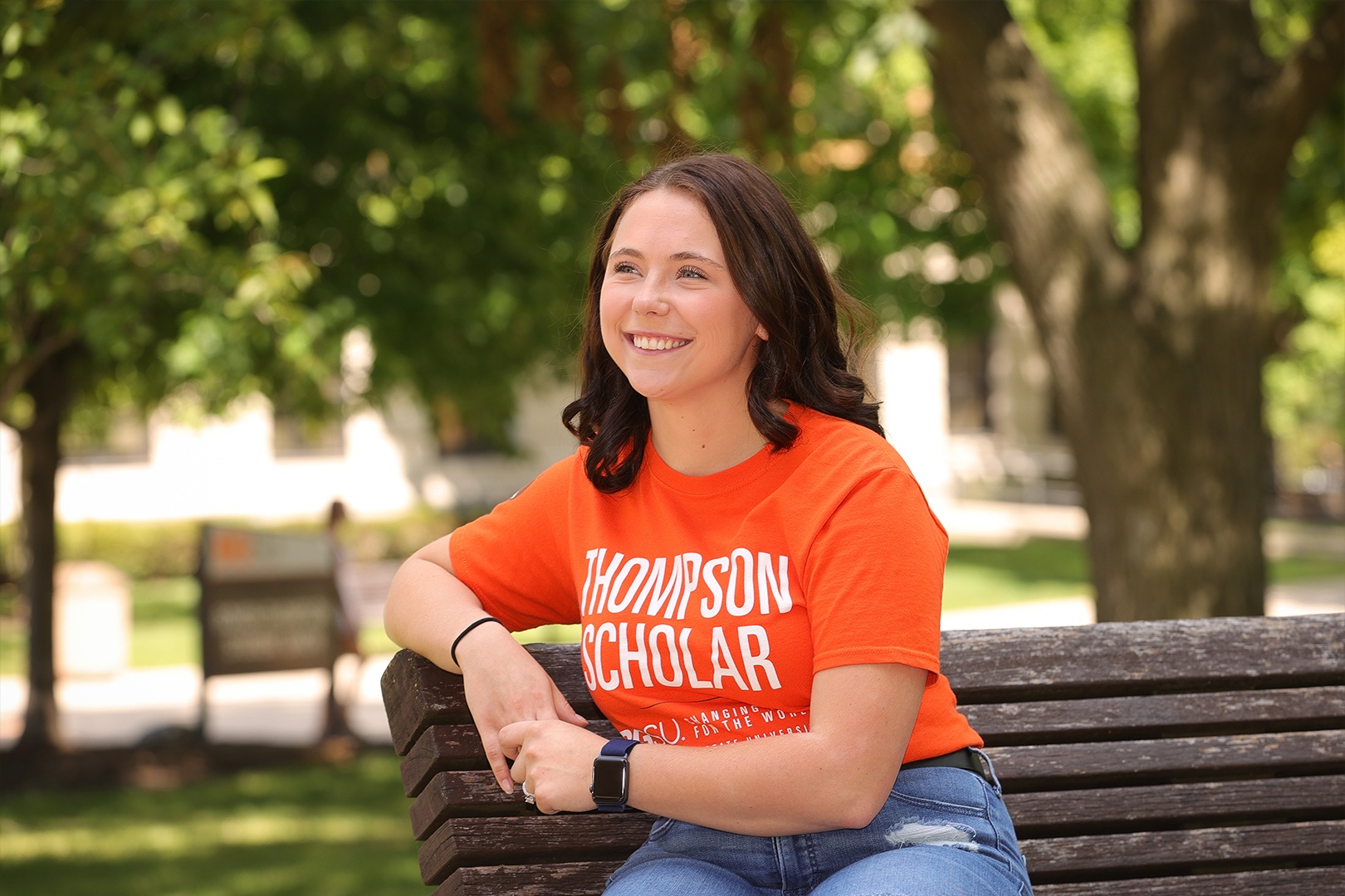 student sitting on bench smiling