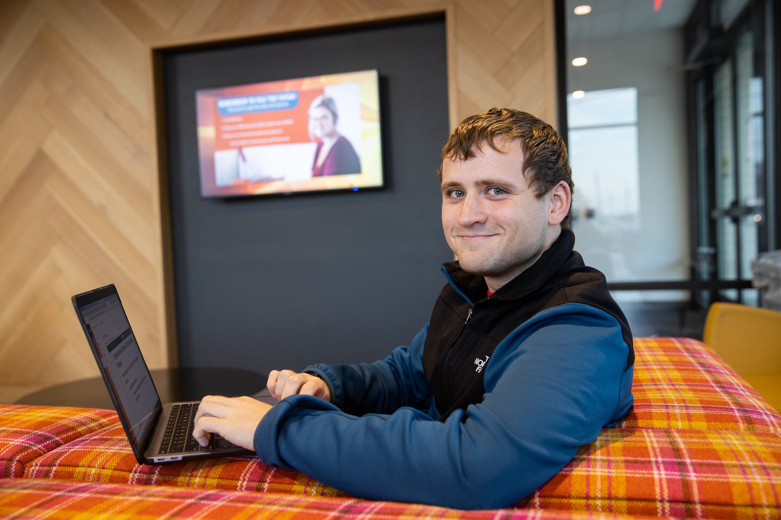 BGSU Firelands Student working on his canvas in an on-campus lobby.