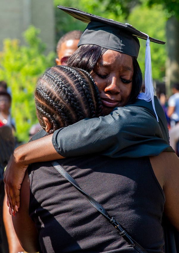 Graduate hugging relative at Commencement