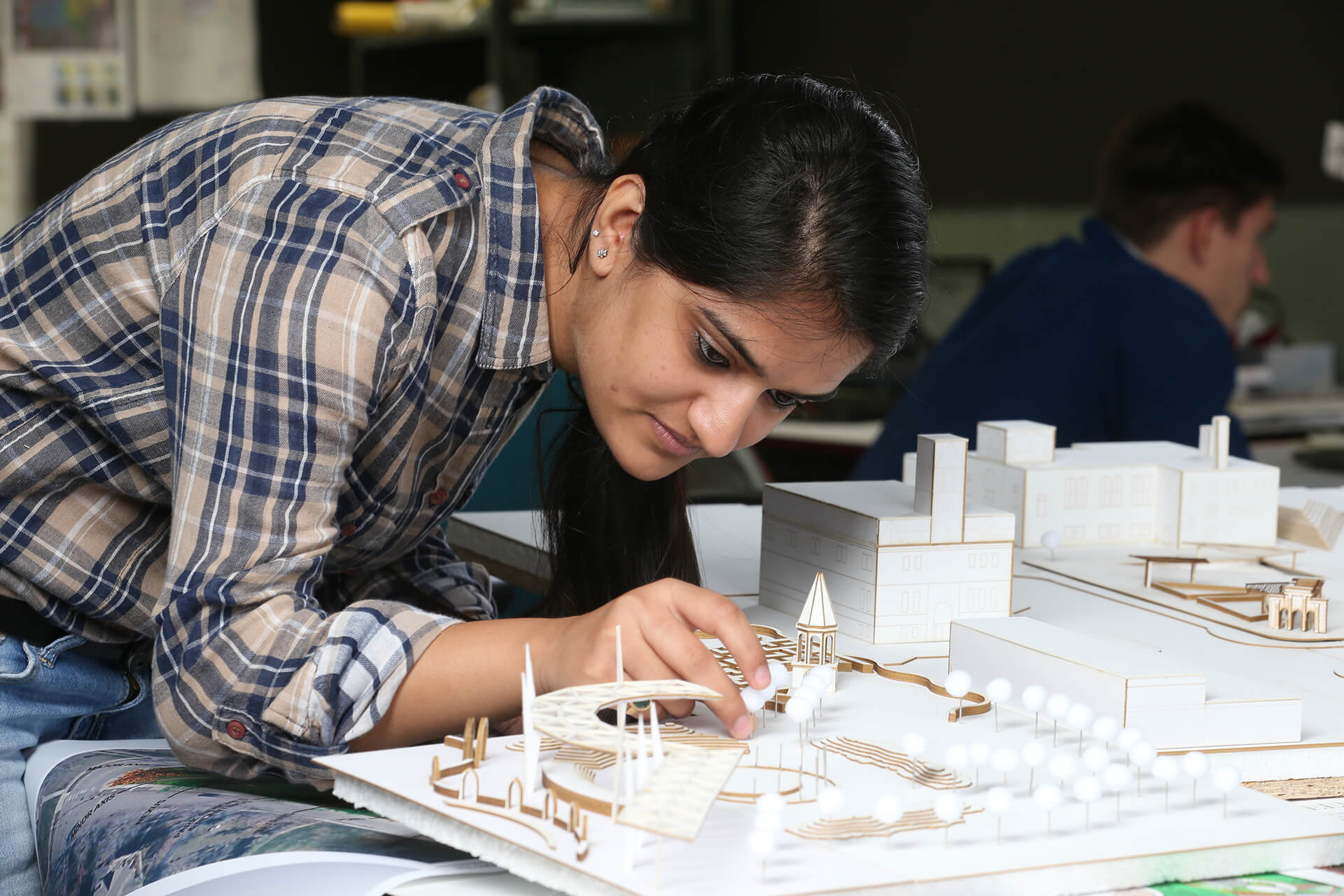 A BGSU architecture and environmental design student working on her building model