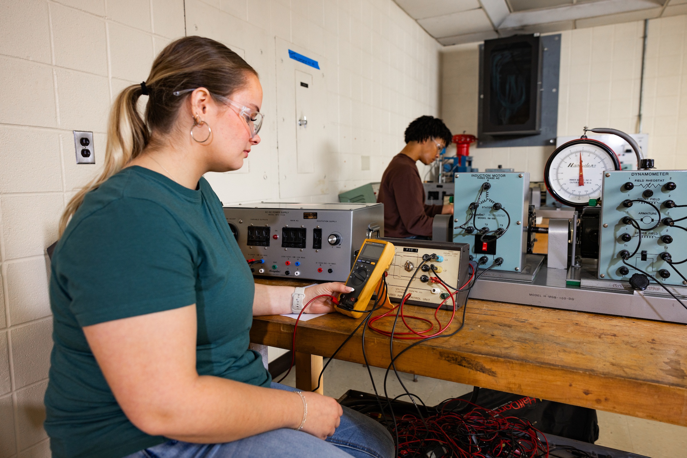 A man sits in an engineering lab working 