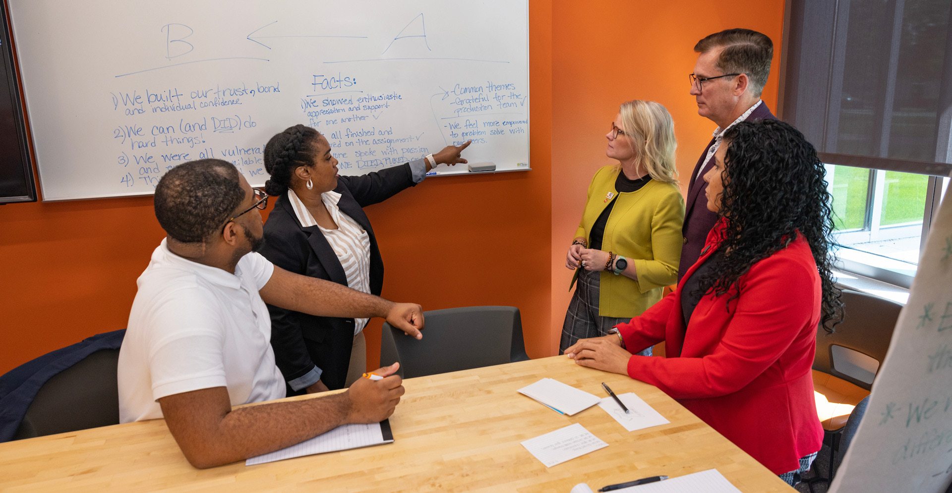 A group of graduate students sit at a table talking