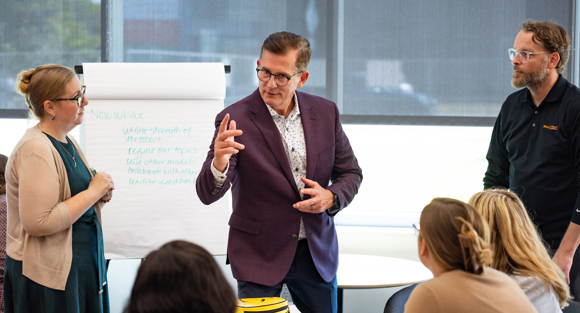 A group of graduate students sit at a table talking