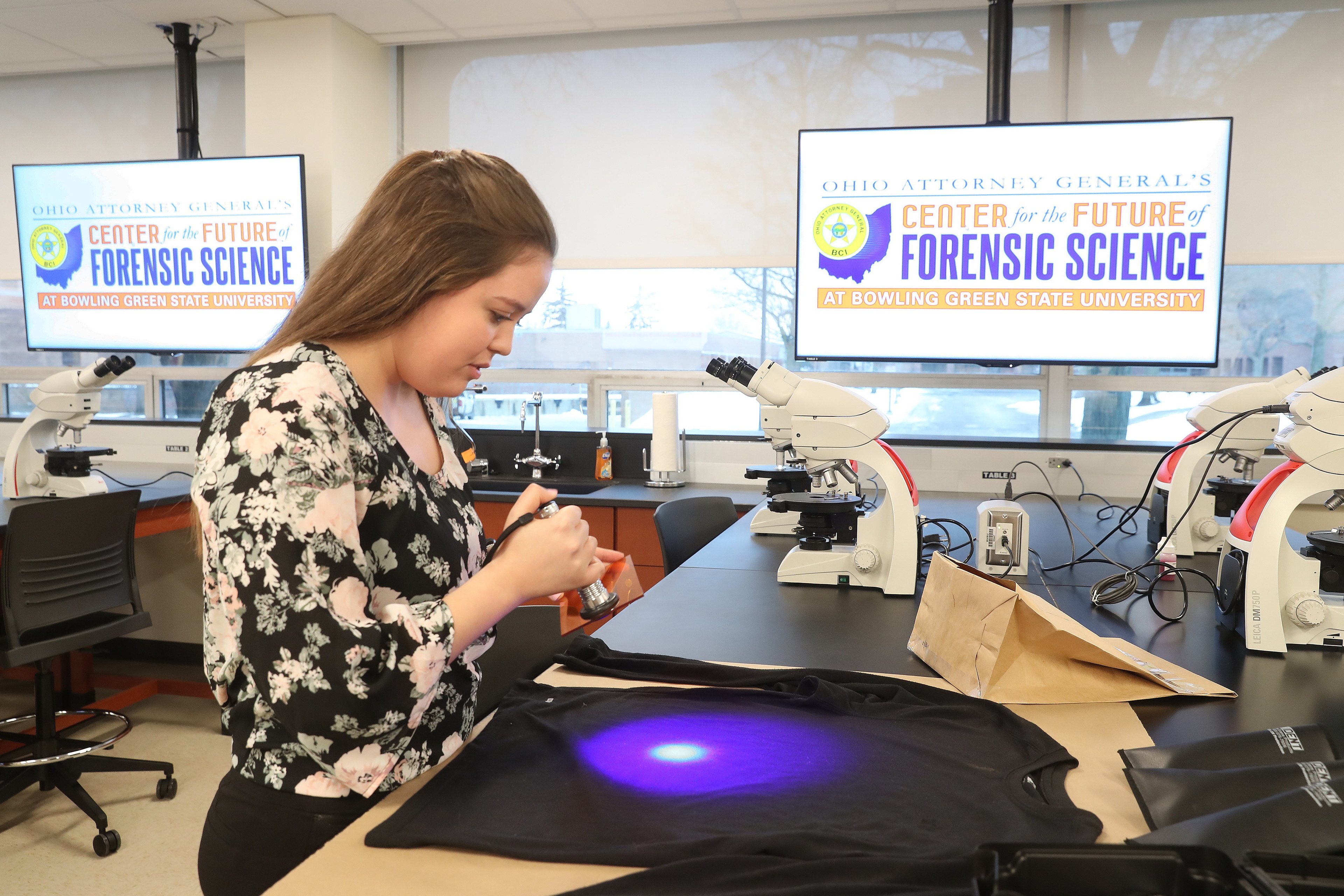 A BGSU Forensic Science Biology student looks for traces of biological material on a simulated piece of evidence in an Ohio lab.