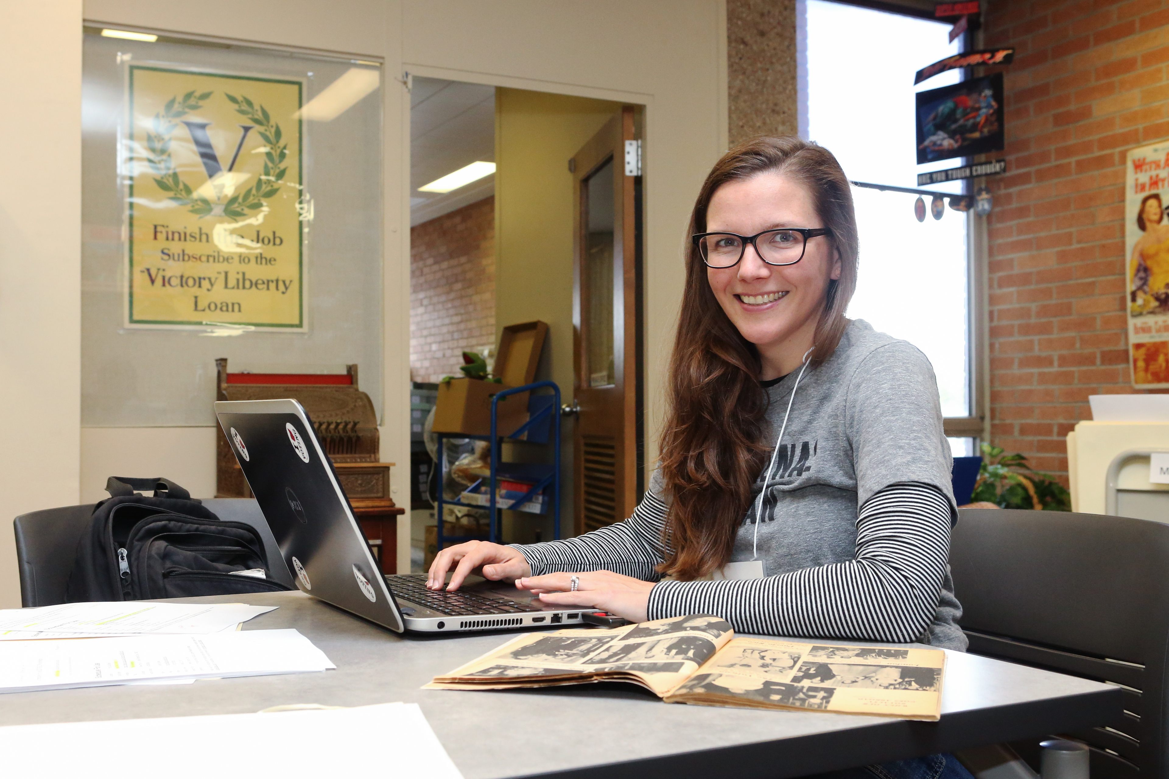 A female BGSU master’s student in popular culture works on a computer and does research in the extensive collections at the popular culture library.