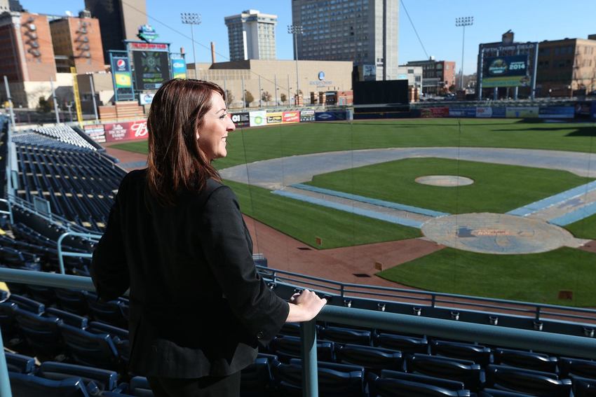 A woman standing at a railing and looking out over the Toledo Mud Hens baseball stadium. 