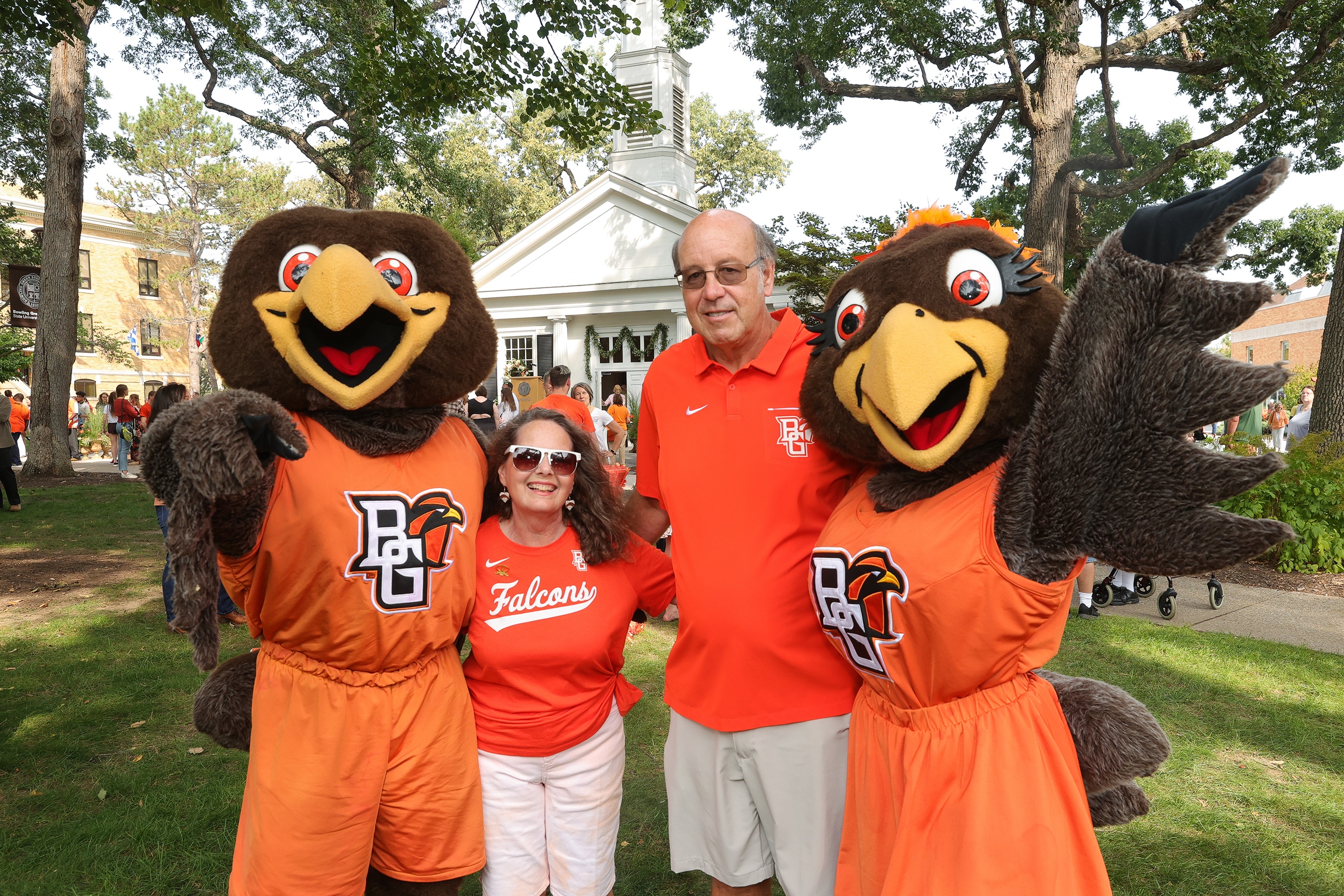 Falcon mascots with BGSU alumni in front of Prout Chapel
