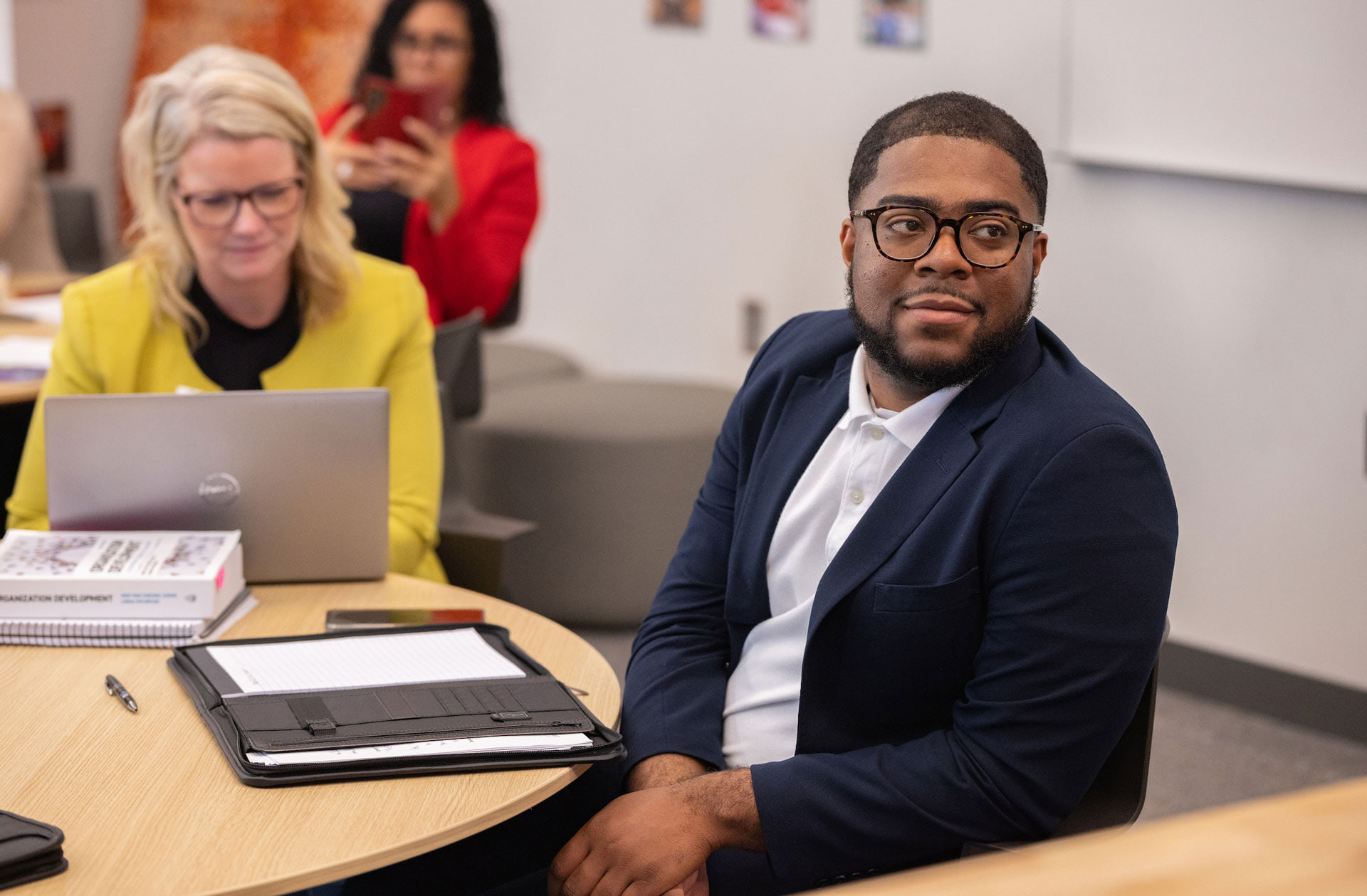A group of graduate students sit at a table talking