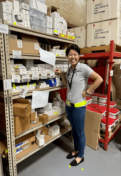 Photo of Yuka Matsufuji standing in a warehouse with boxes.