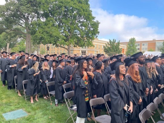 A crowd of students at graduating wearing their cap and gowns.