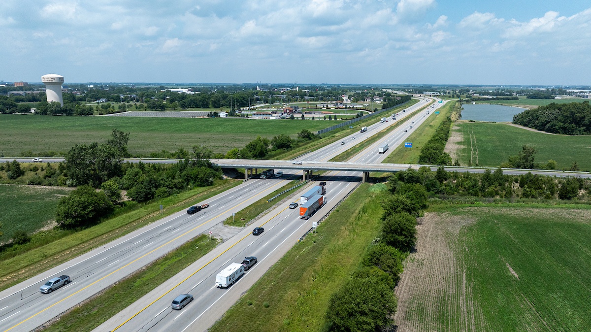 Arial photo of 1-75 highway with cars driving and water tower in the background. 