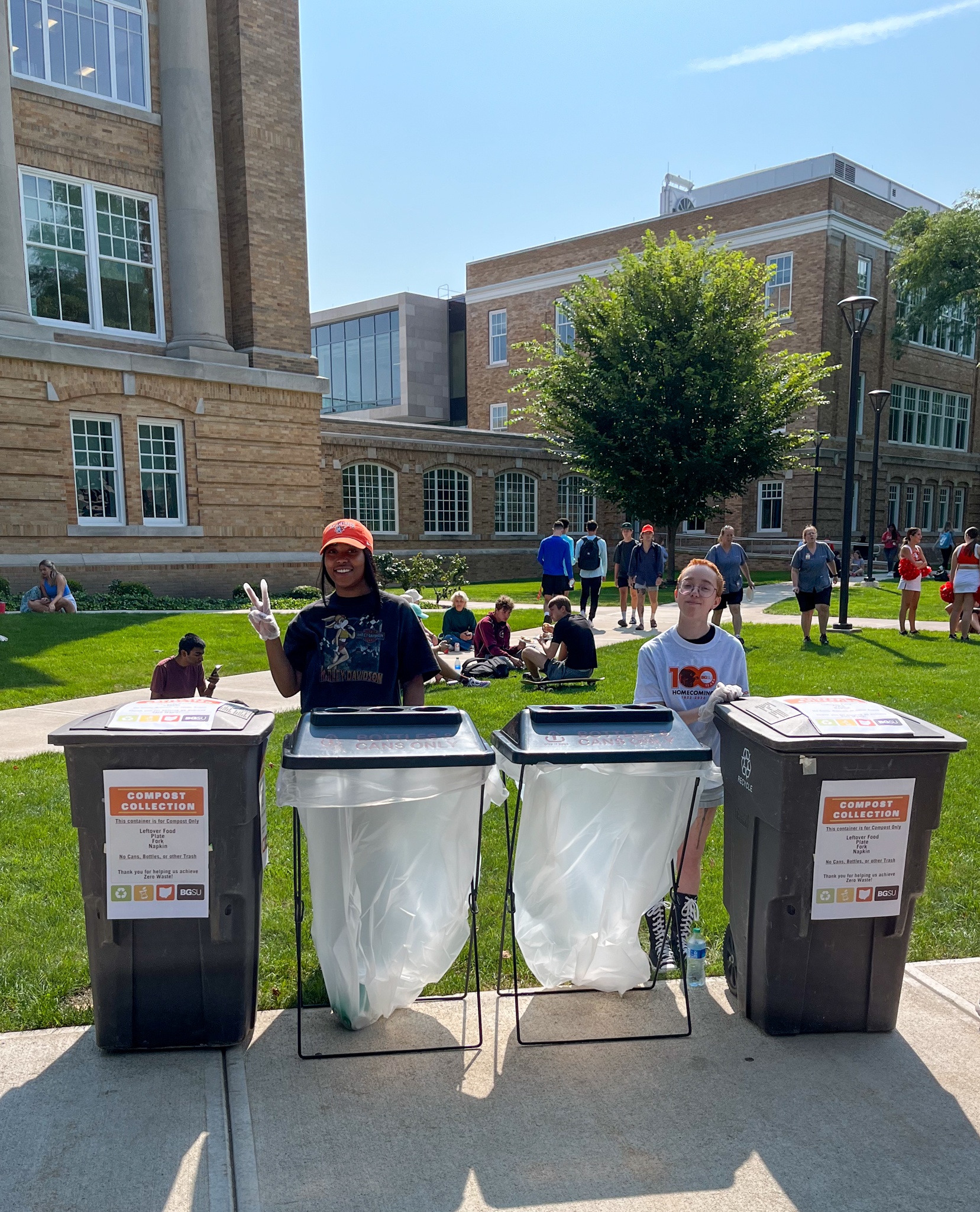 Two students at a Homecoming Picnic Zero Waste station.