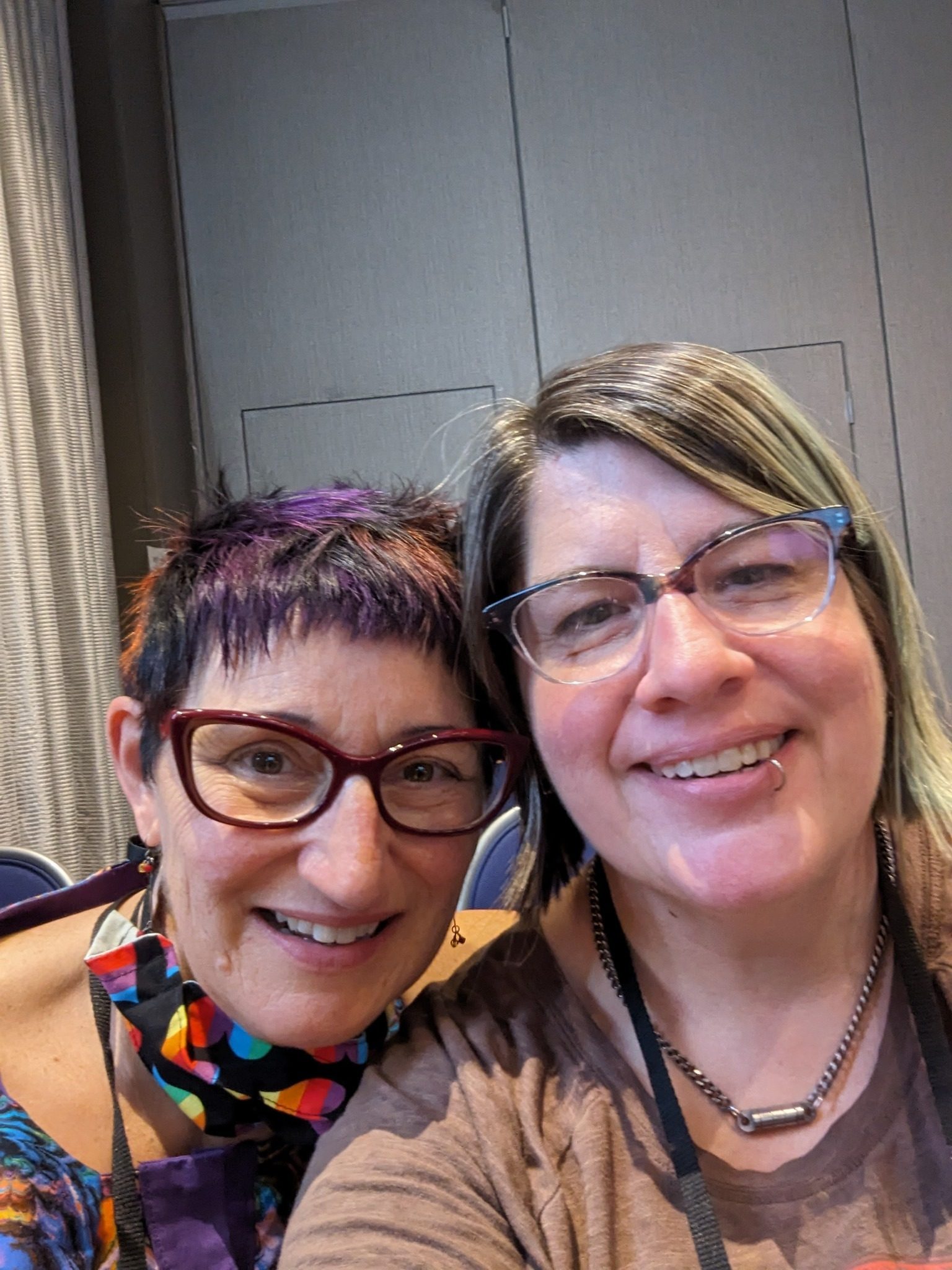 2 middle-aged white women with glasses pose smiling for a selfie