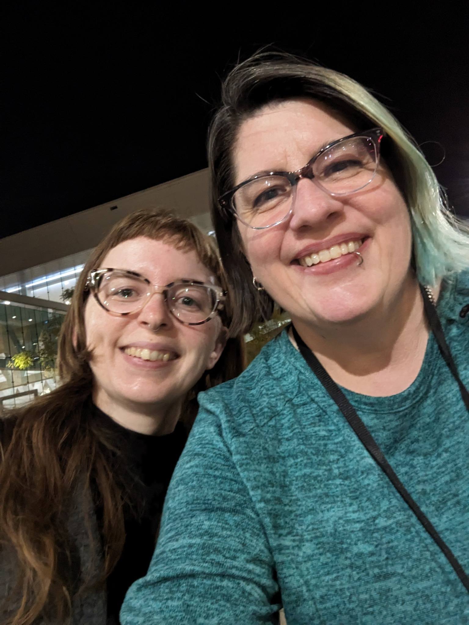 2 white women with glasses pose with smiles for a selfie