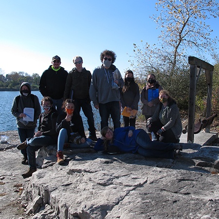 Photo of ten students posing on a rock outcrop at Whitehouse Quarry, Ohio