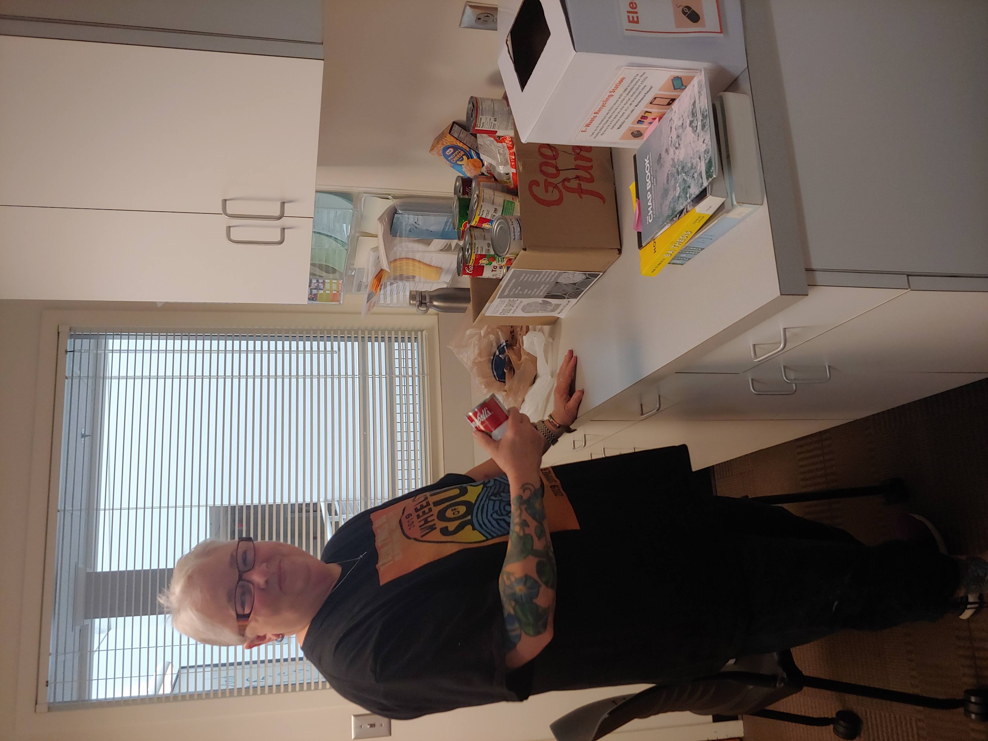 Dr. Cynthia Mahaffey holds donated food in the department office