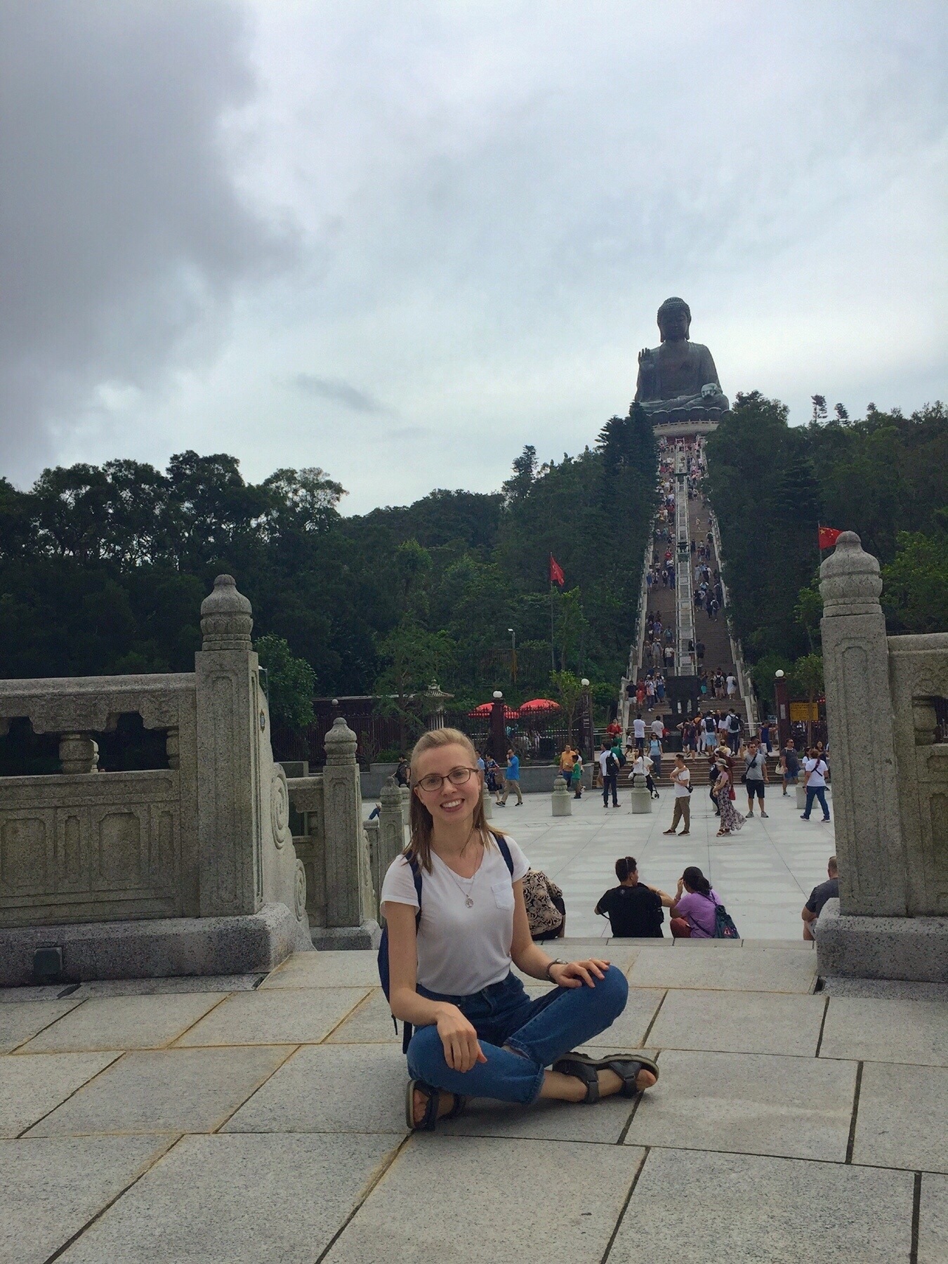 Anastasiia Kryzhanivska seated on the ground, with the "Big Buddha" in the background