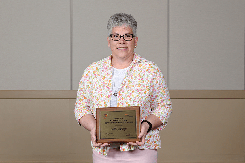Kelly Jennings with the 2019 Classified Staff Outstanding Service Award plaque