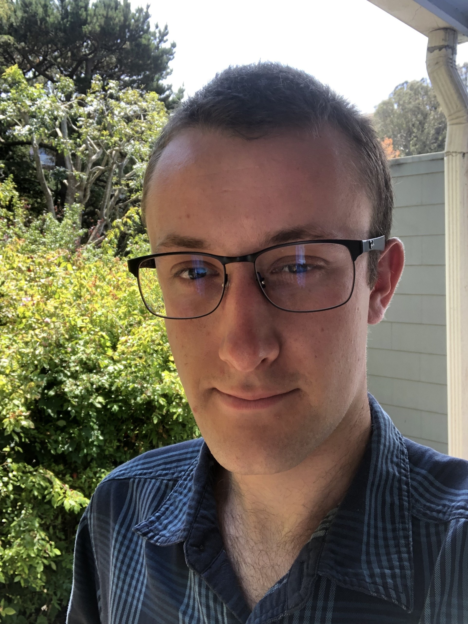 Headshot of Gabe Pine wearing glasses and a blue shirt
