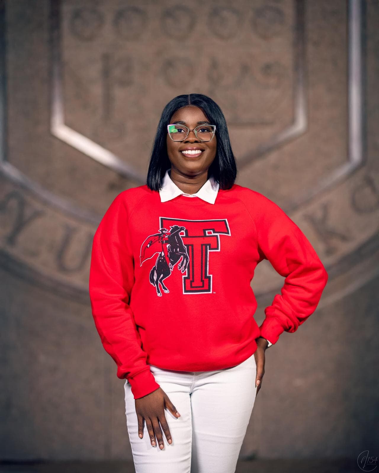 Rhodalene wearing a red sweatshirt and white pants