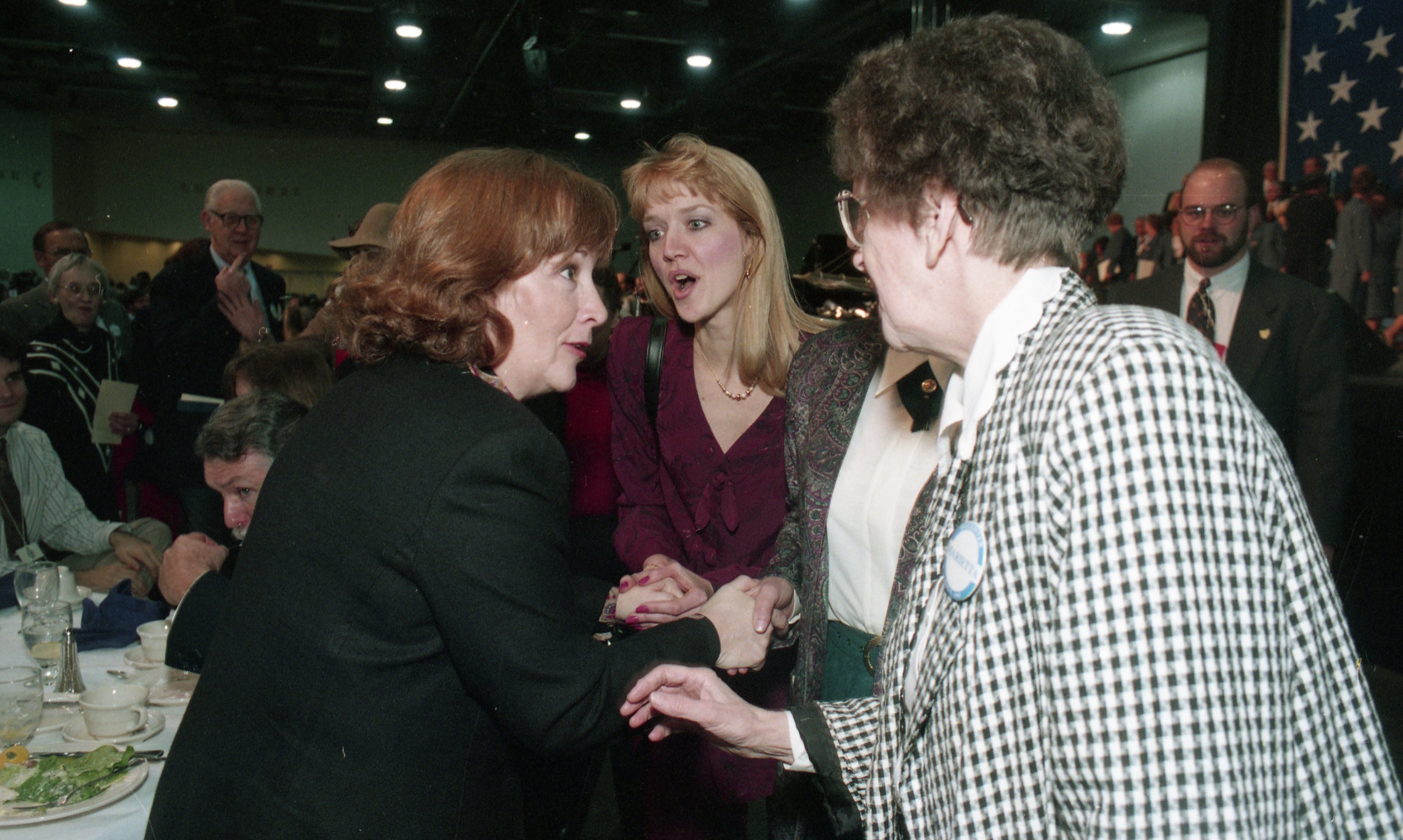 Hollister talking with three people at inaugural luncheon