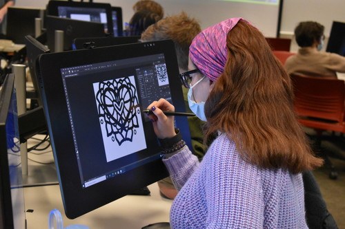 Student draws a design on a Cintiq tablet