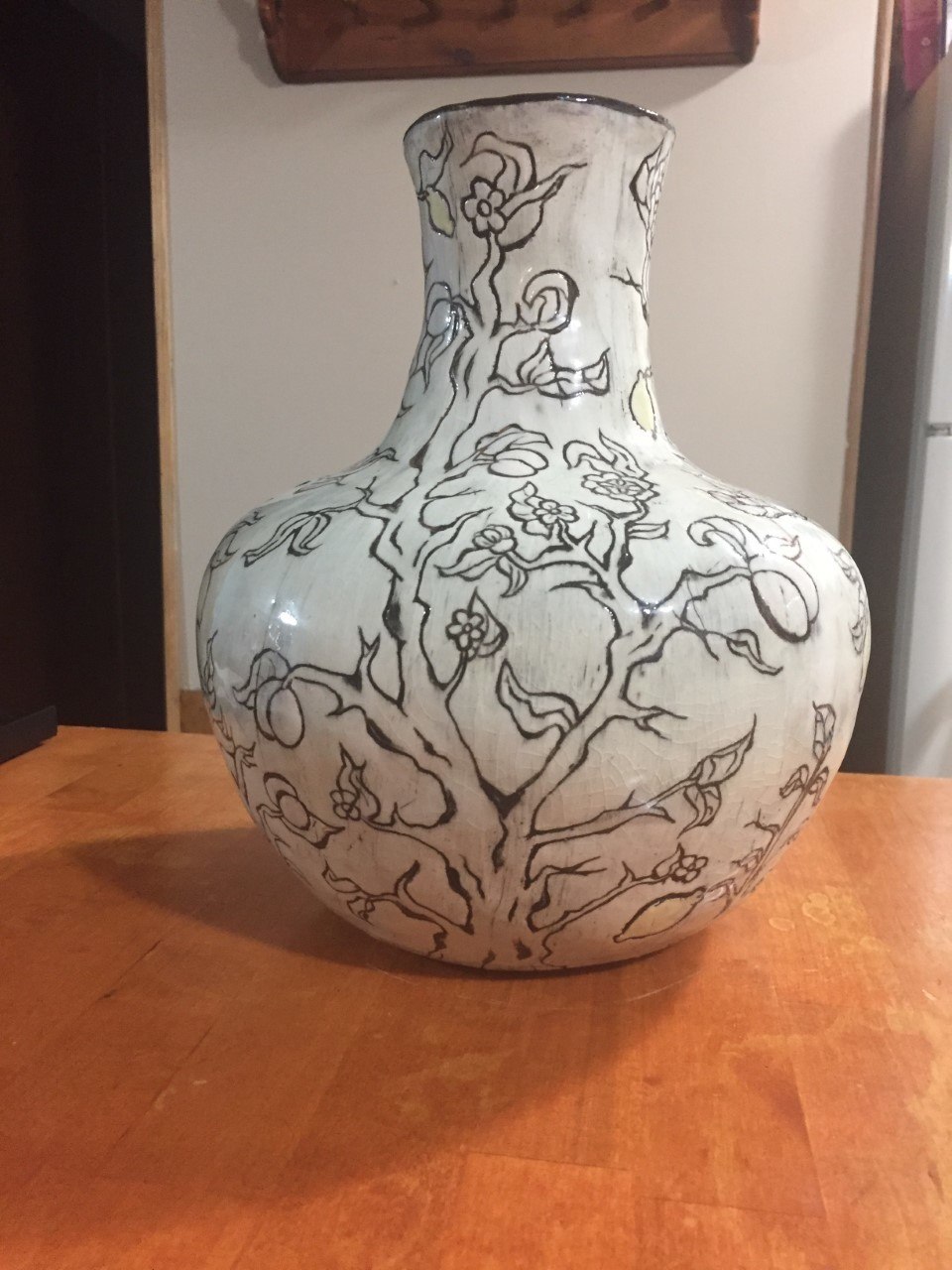 White vase with black line art of a tree