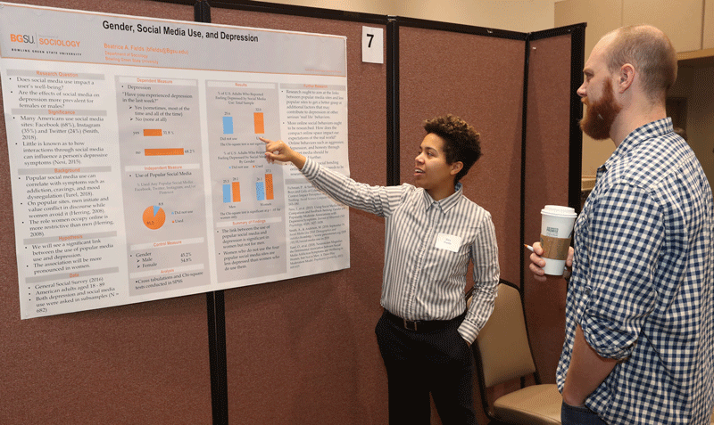 Beatrice Fields presents poster to Assistant Professor John Boman at 2018 fall Capstone