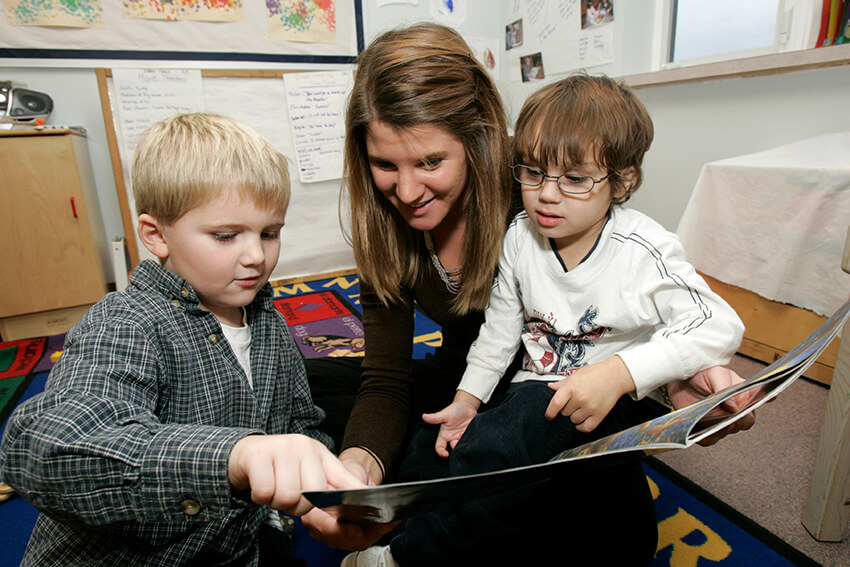 Teacher reading to two young students