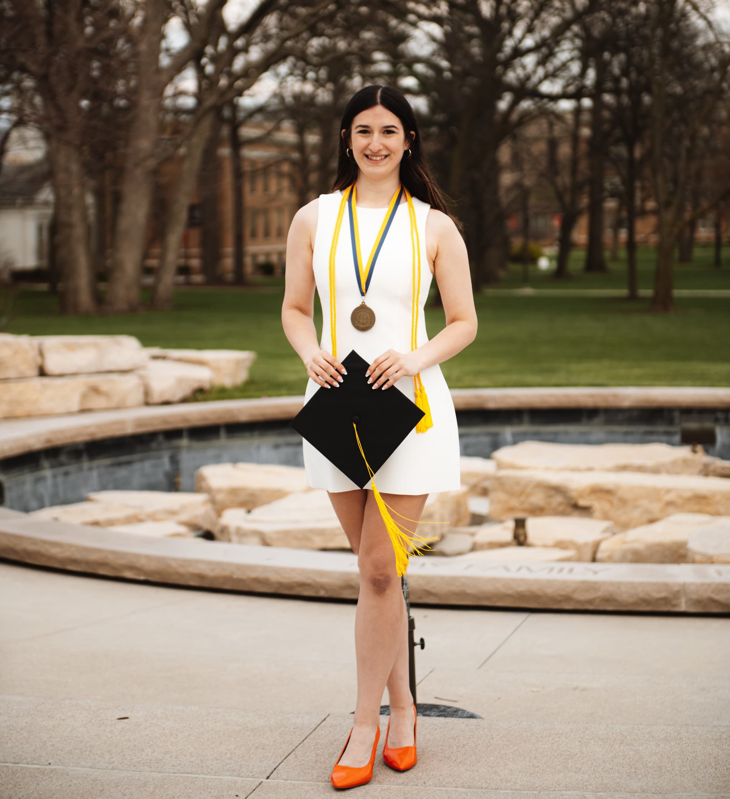 Emily outside in front of BGSU fountain with graduation cap
