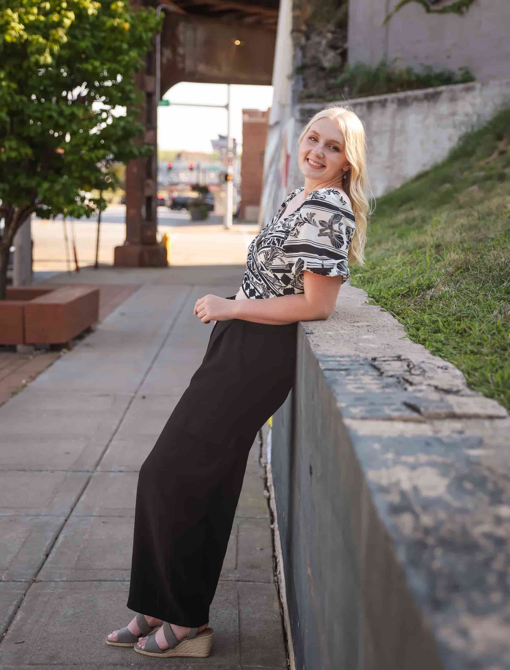 Jenna outside in downtown area leaning against a wall
