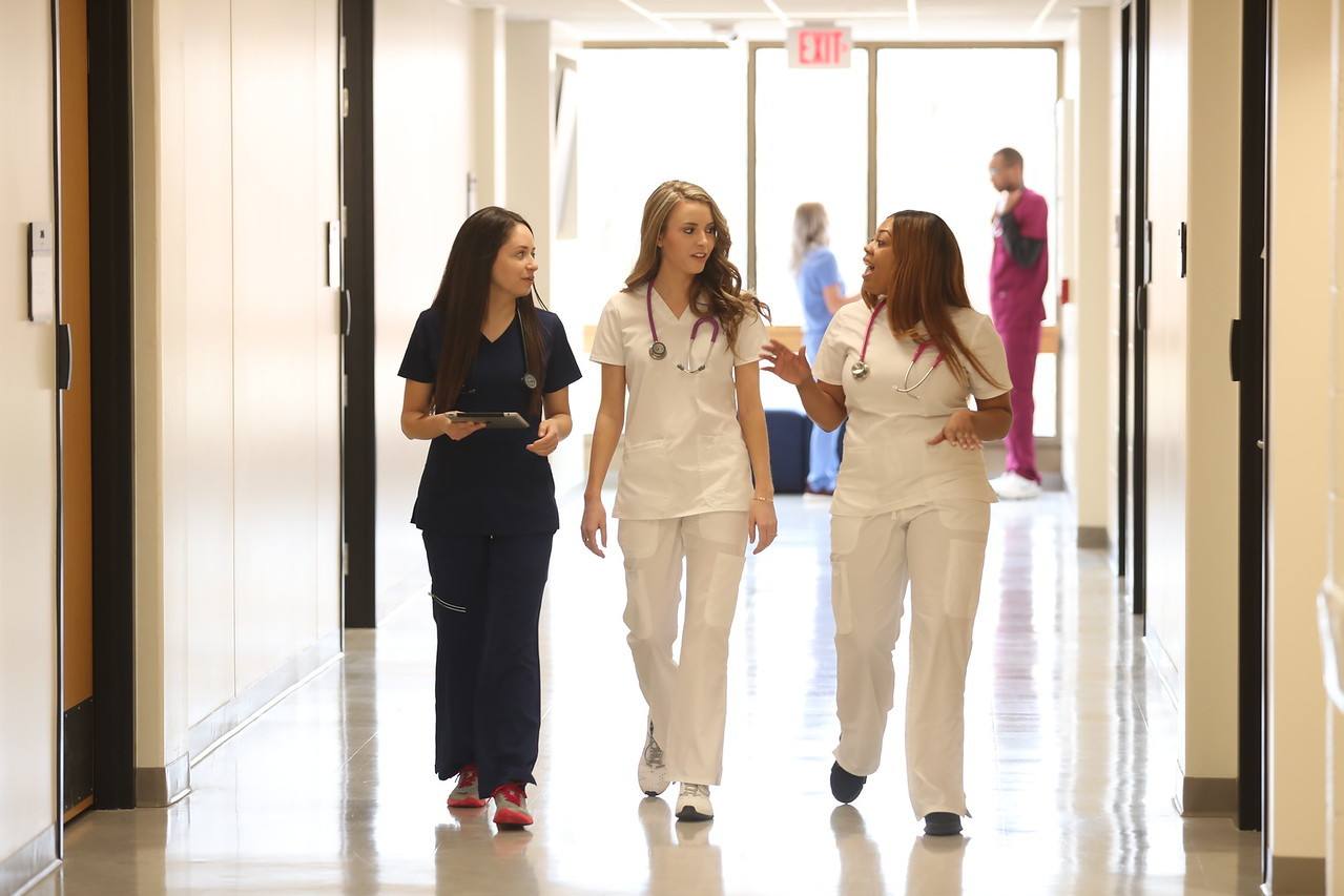 Three Allied Health professionals with online degrees walking down a corridor in new jobs thanks to a BSAH from BGSU.