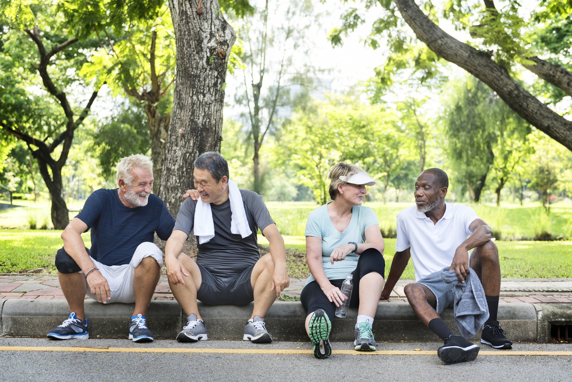 Older individuals sitting on a park curb