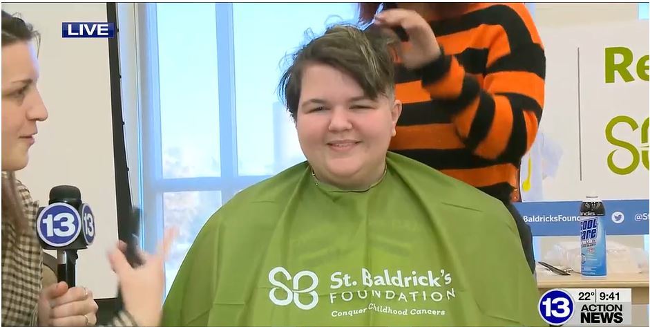 Student Logan with green St. Baldrick's Foundation apron on gets head shaved