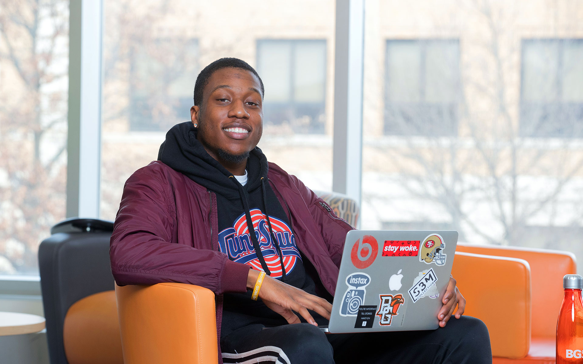 Student using laptop in union smiling at camera