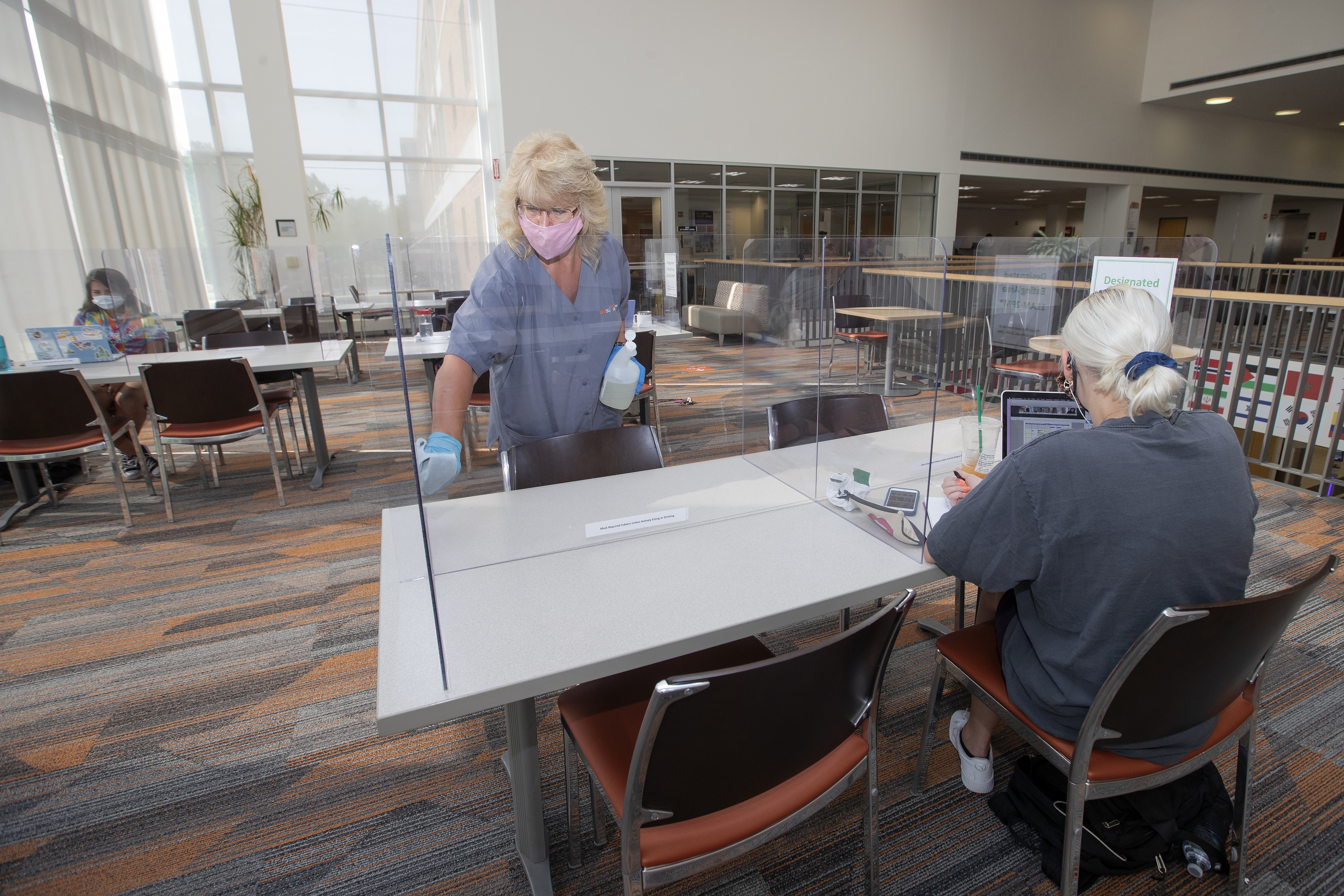 Campus Operations staff member Donna Hackworth cleans a seating area