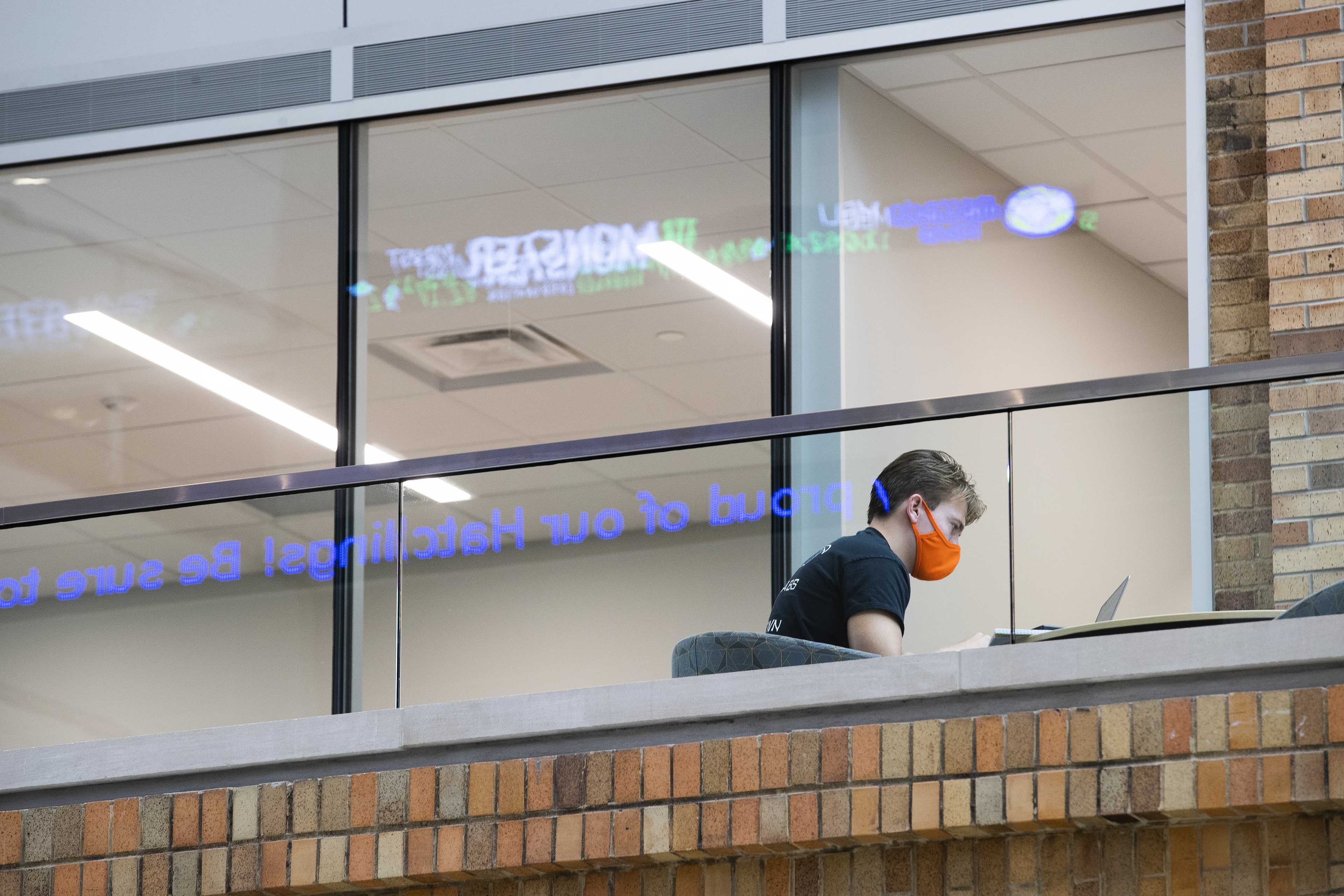 The Maurer Center’s scrolling news and stock ticker reflects on the glass while A. J. Mahnke, a sophomore finance major from Archbold, Ohio, studies.