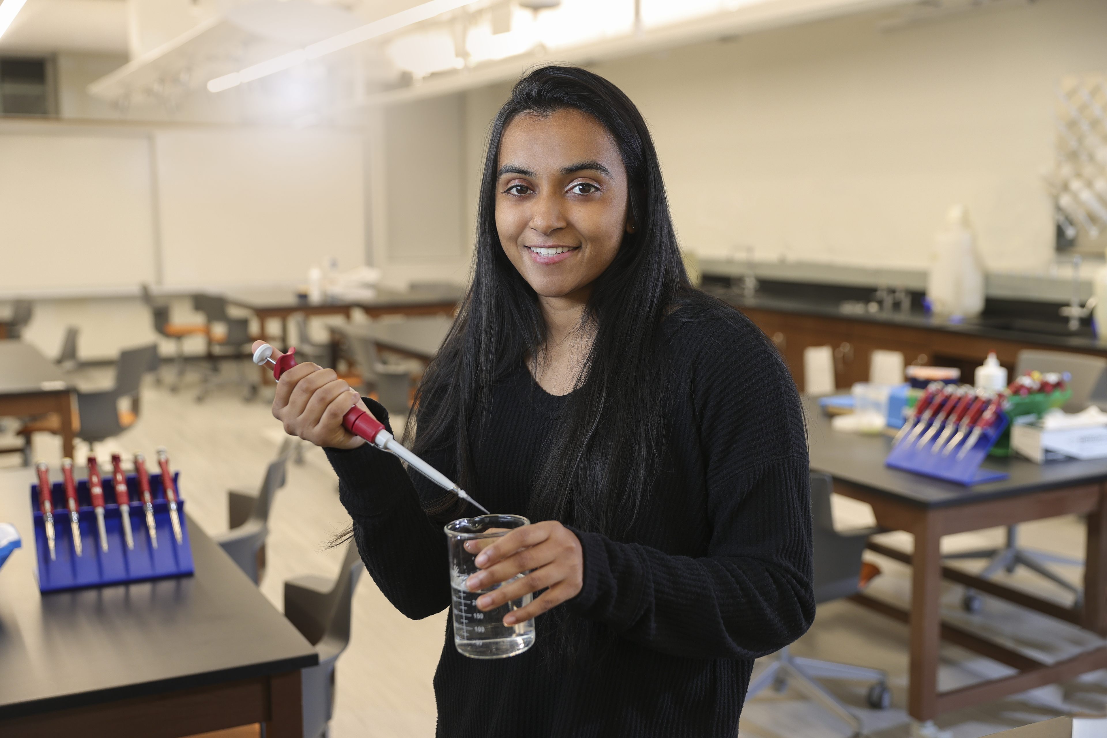 Nikhita Jacob smiling while holding a test tube