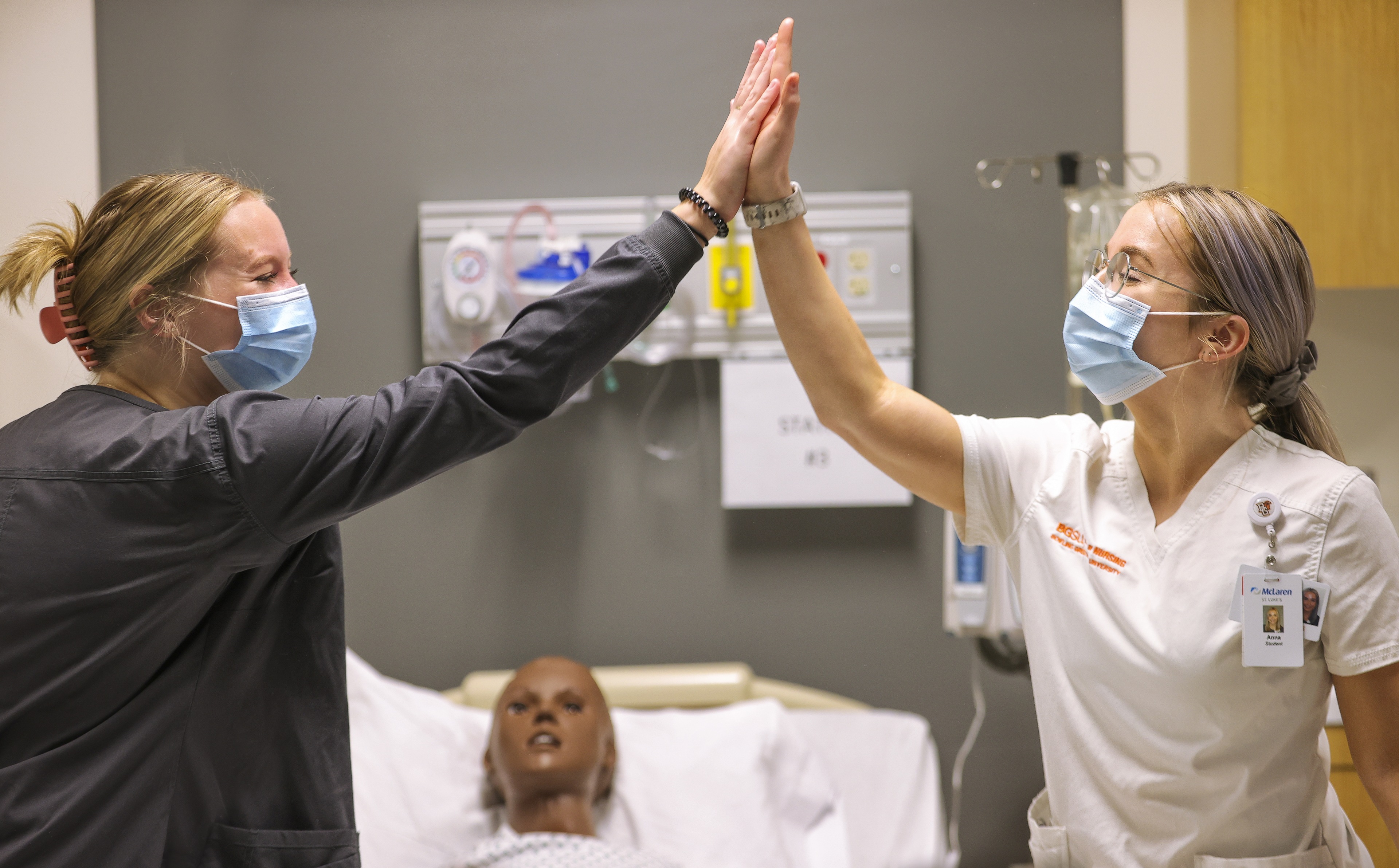 (Left-to-right) Nichole Seal, a junior from Kent, Ohio, and Anna Winger, a junior from Tiffin, Ohio, give each other a high five after successfully performing several procedures in the skills lab.