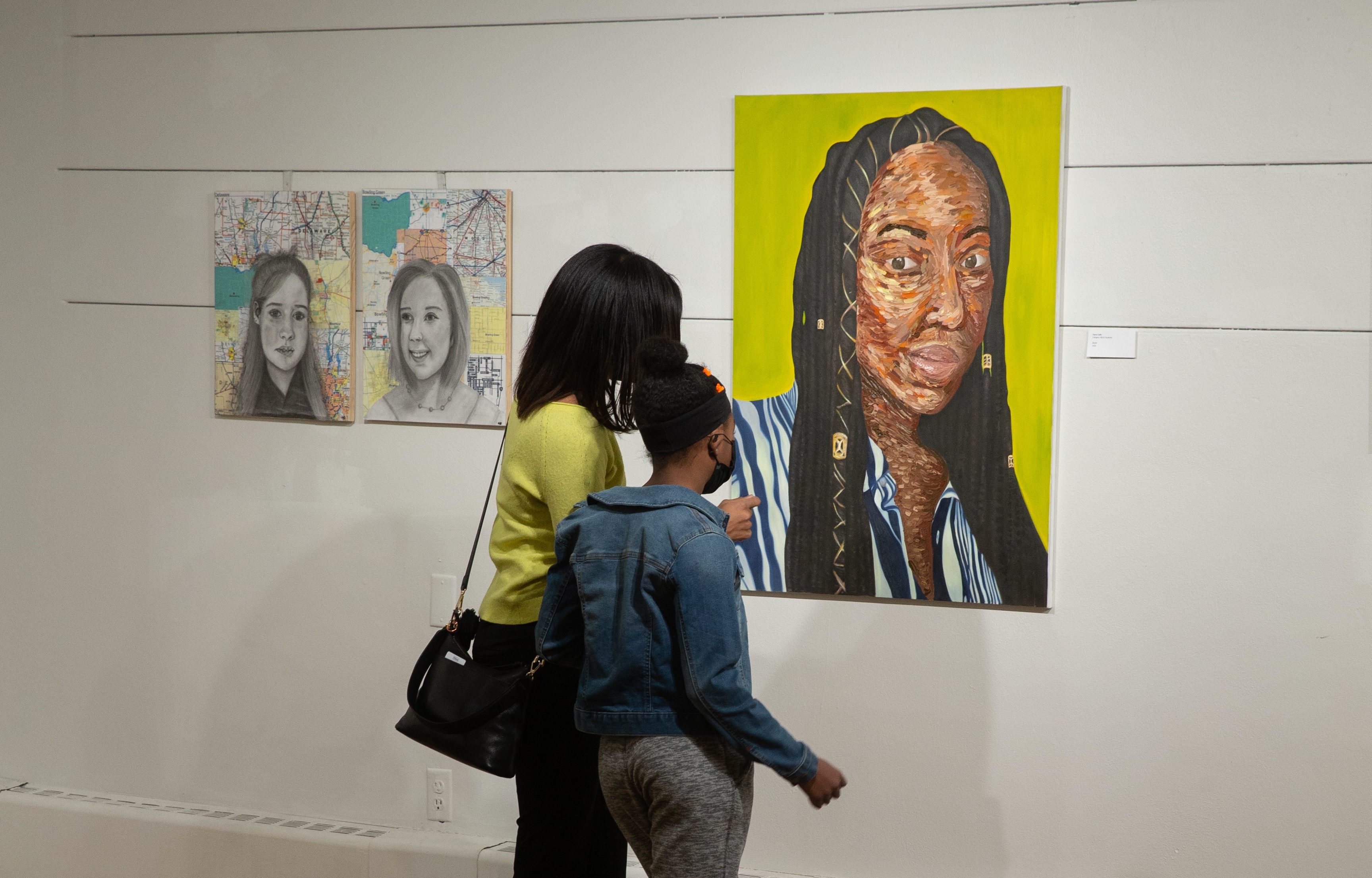 A lady and a child looking at a Diversity and Belonging painting