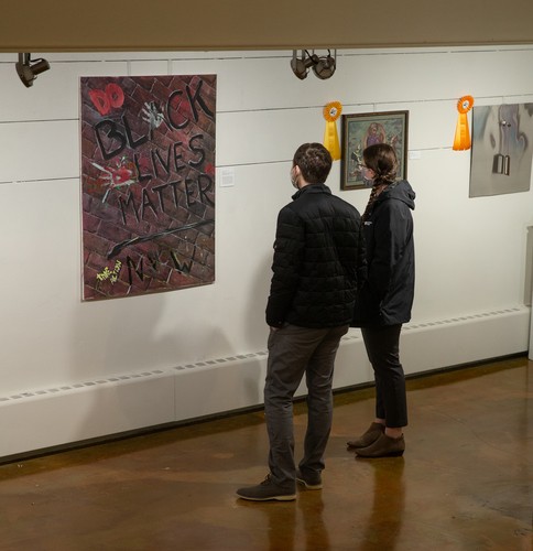 Two people looking at a Black Lives Matter painting