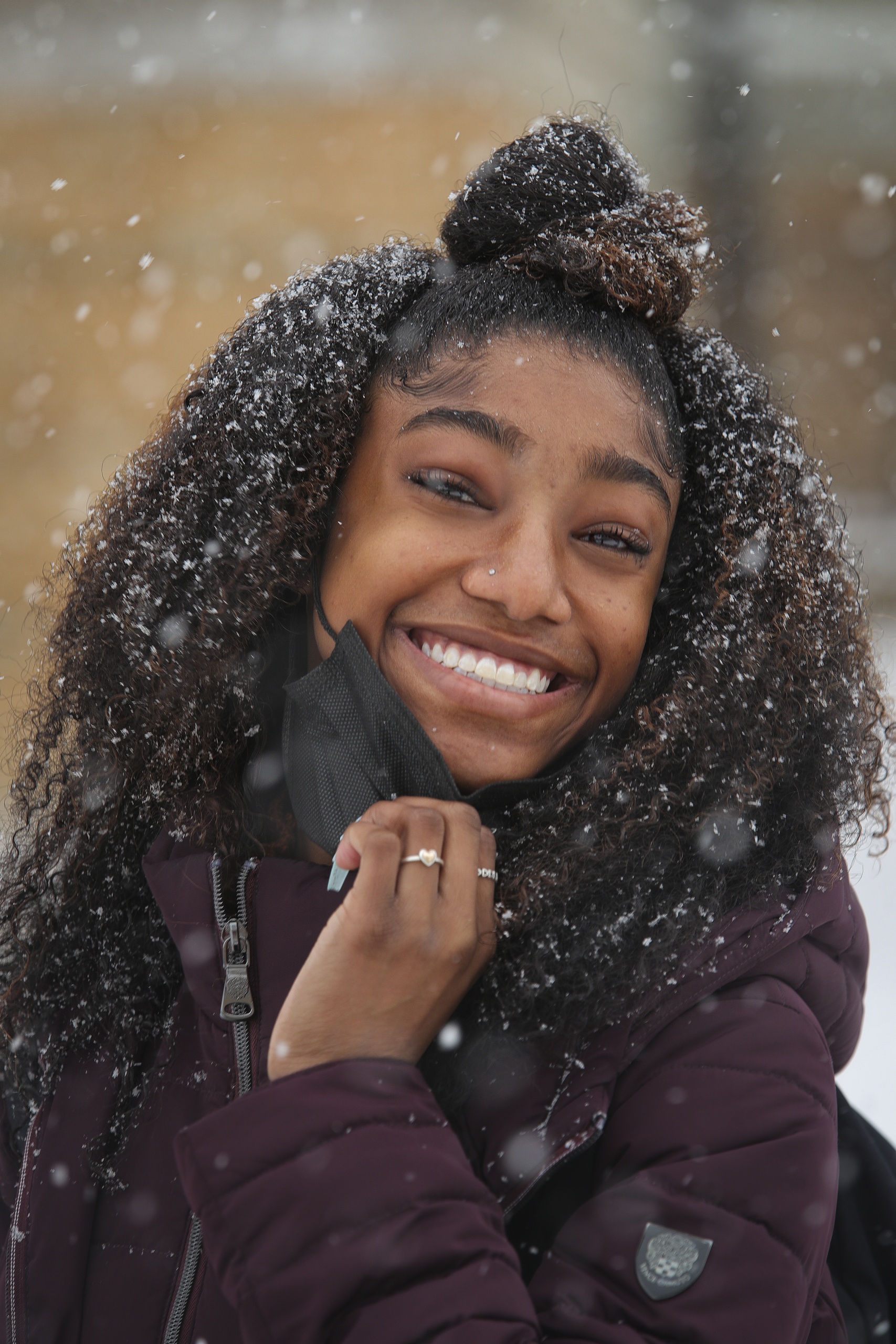A student smiles, enjoying a chilly walk across campus.