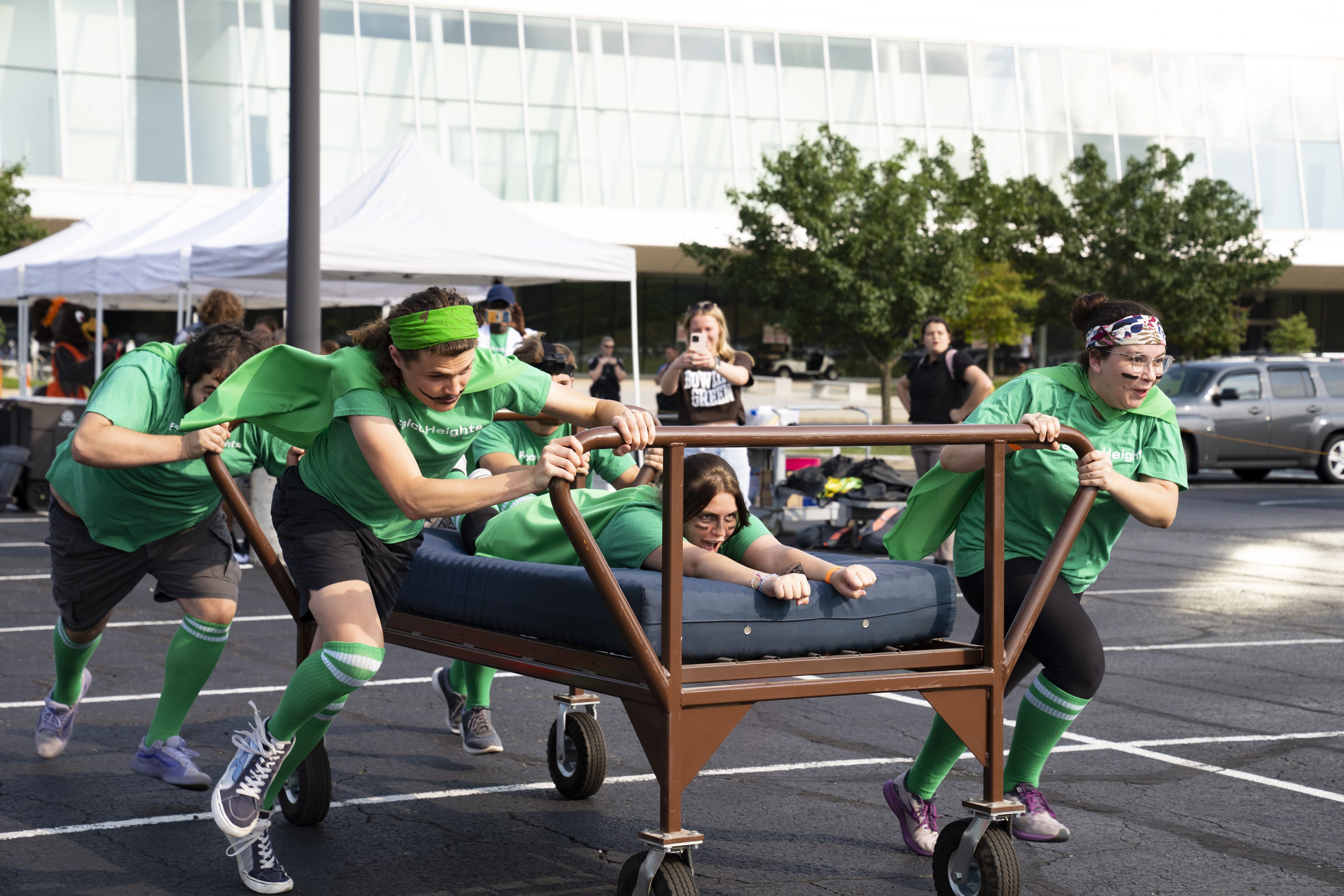 Students push a wheeled bed during a race